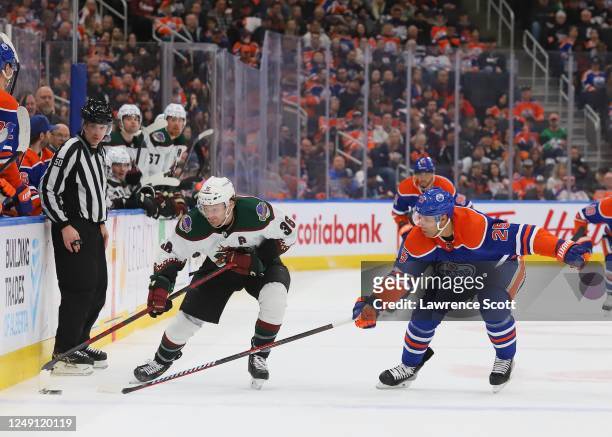 Christian Fischer of the Arizona Coyotes battles for the puck with Darnell Nurse of the Edmonton Oilers in the third period at Rogers Place on March...
