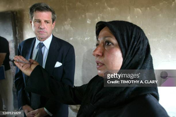 An Iraqi teacher shows US overseer Paul Bremer a burnt-out classroom at the Al-Huda primary co-educational school 07 June 2003 in Baghdad. Bremer...