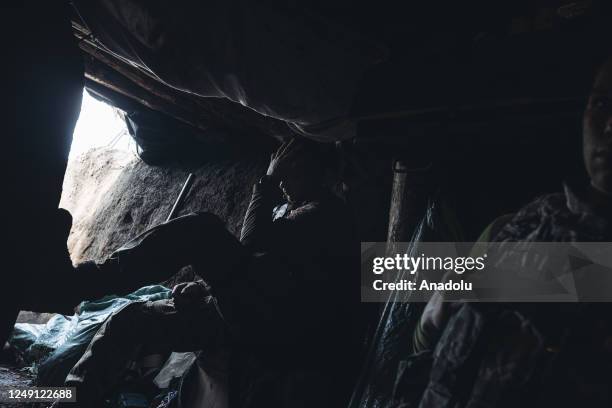 Ukrainian soldier take shelter from Russian shelling in a trench in the direction of Bakhmut, 22 March 2023.