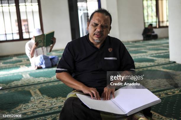 Visually impaired men read a Braille Quran at a mosque in South Tangerang, Banten, Indonesia, on March 23, 2023. Braille Quran is the translation of...