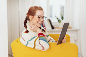 Smiling happy young woman reading on a tablet