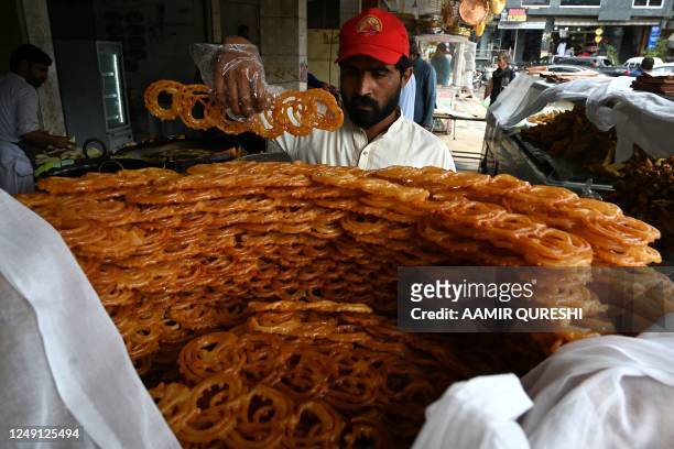 Baker arranges sweet 'Jalebi' Iftar food for Muslim devotees to break their fast on the first day of the Islamic holy month of Ramadan, at a shop in...