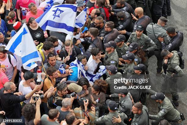 Israeli police confront protesters during ongoing demonstrations in Tel Aviv on March 23 against controversial legal reforms being touted by the...