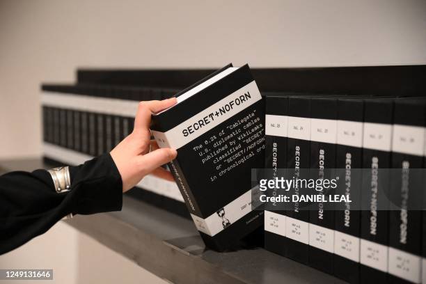 Member of gallery staff poses during a photo call, with 'SECRET+NOFORN' by the Institute for Dissent and Datalove, which comprises all of the...