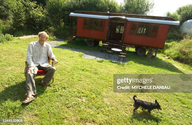 Antoine Arnoux, un architecte paysagiste de 46 ans, pose, le 13 juillet 2006 à Saint-André d'Hébertot, devant l'une des roulottes qu'il a aménagé en...