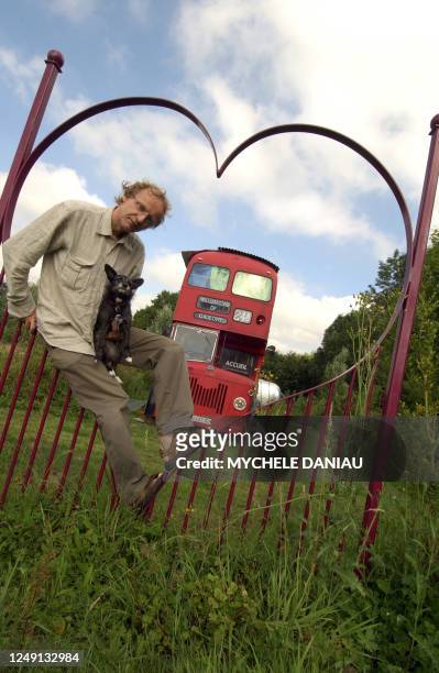 Antoine Arnoux, un architecte paysagiste de 46 ans pose le 13 juillet 2006 à Saint-André d'Hébertot, devant un bus impérial écossais qu'il a aménagé...