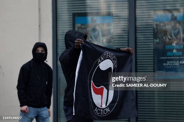 An Anti Fascist Action flag is displayed by a protester during a demonstration on a national action day, a week after the government pushed a...