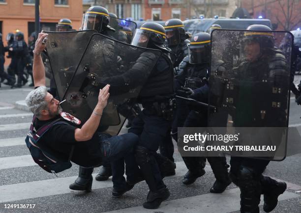 French Republican Security Corps police officers in riot gear clash with a protestor during a demonstration, a week after the government pushed a...