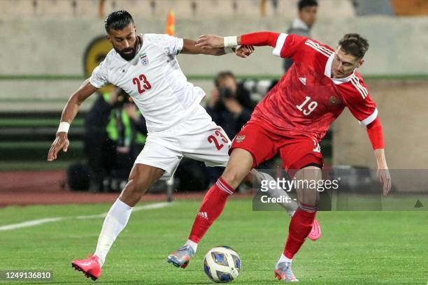Iran's defender Ramin Rezaeian vies for the ball against Russia's midfielder Anton Miranchuk during the friendly football match between Iran and...