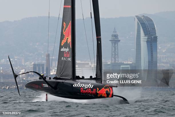 Alinghi Red Bull Racing's AC75 racing yatch sails, with the Vela building and the Jaume I tower in the background, during a training session ahead of...