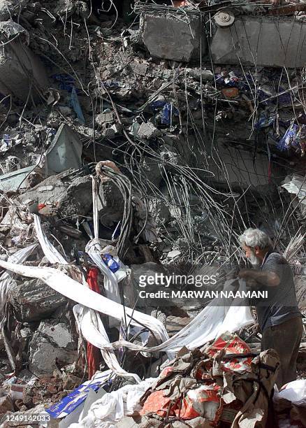 Man tries to salvage cloth 20 July 2000 from the wreckage of a six-storey clothing factory which caught fire and collapsed 19 July in the northern...