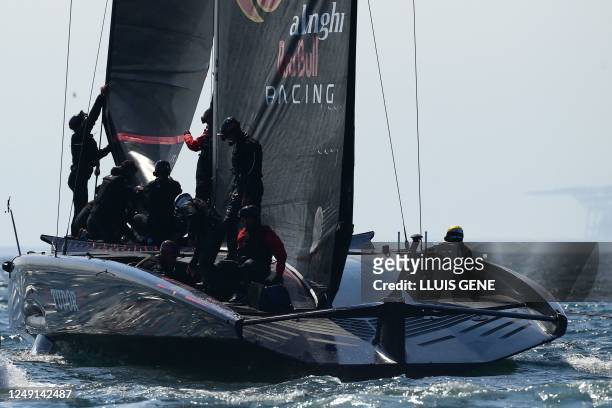 Alinghi Red Bull Racing's crew members check the sails of the AC75 racing yatch during a training session ahead of the 37th America's Cup sailing...