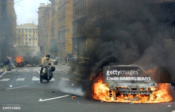 Car set on fire burns during an anti-globalisation rally against the Group of Eight summit in Genoa 20 July 2001. Leaders from the world's seven most...