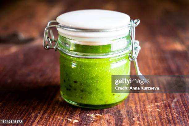 jam with kiwi and gooseberry in a jar on a wooden table, selective focus - kiwi foto e immagini stock