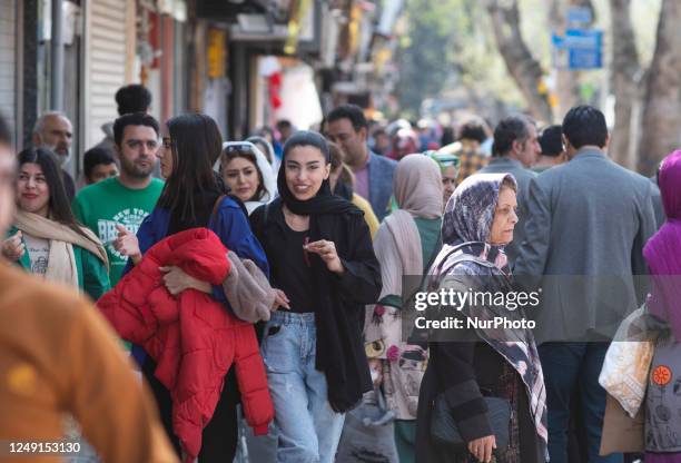 Young Iranian woman smiles as she walks along a street near a local bazaar in the city of Rasht in Gilan province 330Km northwestern Tehran, on the...