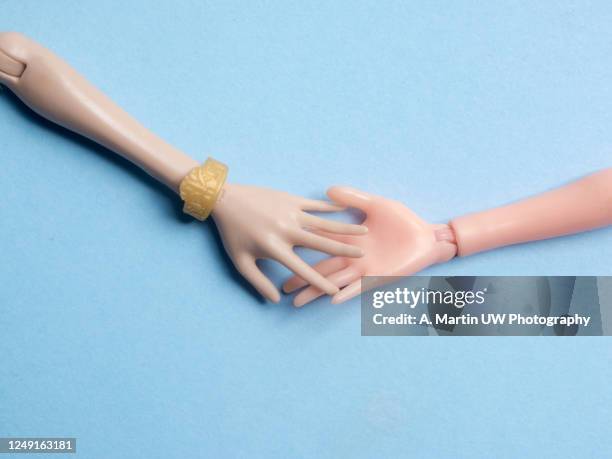 doll's hands holding on to a light blue background - doll stock pictures, royalty-free photos & images
