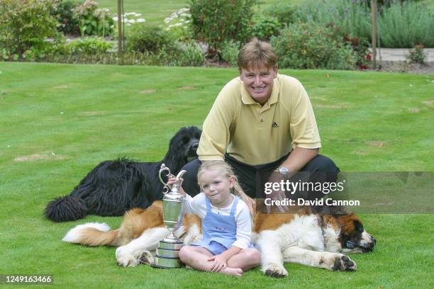 Ernie Els of South Africa the 2002 Open champion, poses for a photograph with The Claret Jug beside his daughter Samantha Els and their family dogs...