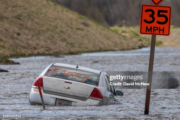 In an aerial view, a car is left stranded in widespread flooding as a series of atmospheric river storms melts record amounts of snow in the Sierra...