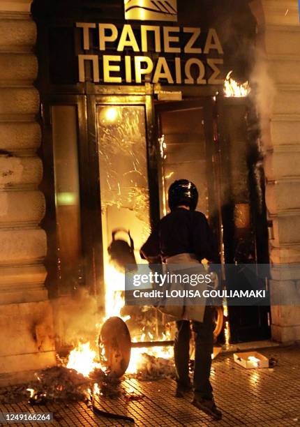 Protestor thows a can into a burning bank in Athens during riots and chaos in Athens on December 8, 2008. Fury at the fatal police shooting of a...