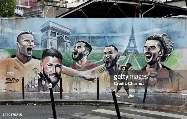 Pedestrian walks past a mural fresco by French street artist Ernesto Novo depicting French football players playing in Spain's La Liga Valencia CF's...