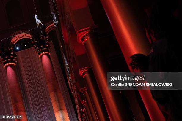 French high-wire artist Philippe Petit performs "Wonder on the Wire" above diners during a fundraiser at the National Building Museum March 23 in...