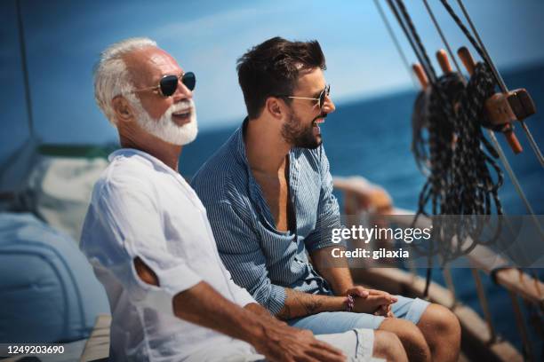 vater und sohn segeln. - eltern sonnenbrille sonne lachen stock-fotos und bilder