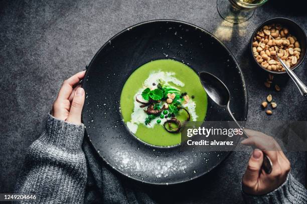 woman preparing vegan green soup - pea and mint soup stock pictures, royalty-free photos & images