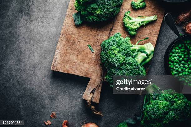 brócoli fresco en tabla de cortar - brécol fotografías e imágenes de stock