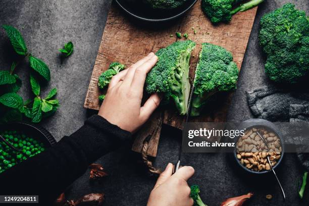 frau schneidet frischen brokkoli - food top view stock-fotos und bilder