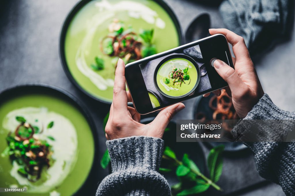 Femme photographiant la soupe verte fraîche