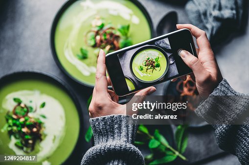 Woman photographing fresh green soup Woman photographing fresh green soup