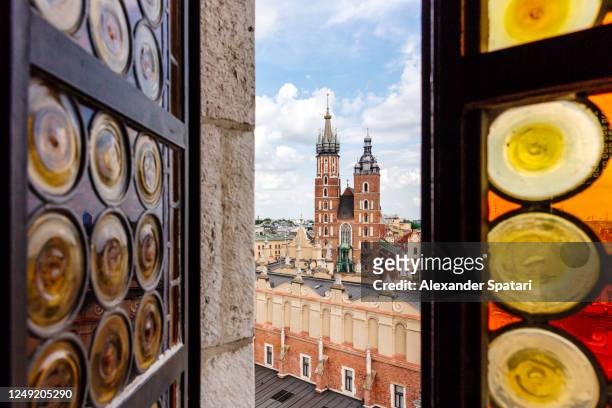 krakow skyline with st mary's church seen through an open window, poland - krakow fotografías e imágenes de stock