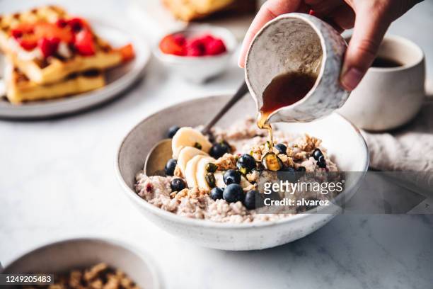 frau bereitet leckeres frühstück zu - porridge stock-fotos und bilder