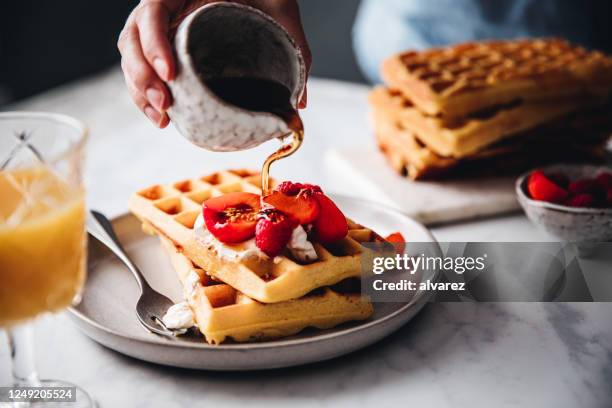 woman serving sweet and tasty breakfast - belgium waffles stock pictures, royalty-free photos & images