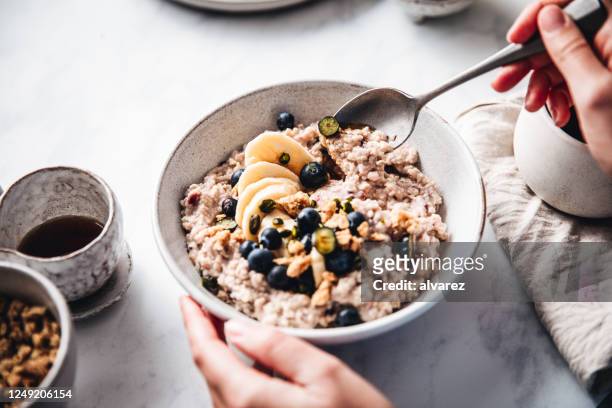 frau macht gesundes frühstück in der küche - speisen und getränke stock-fotos und bilder