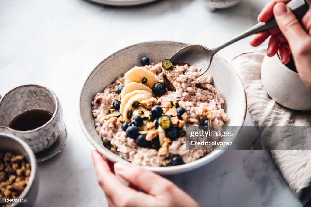Vrouw die gezond ontbijt in keuken maakt
