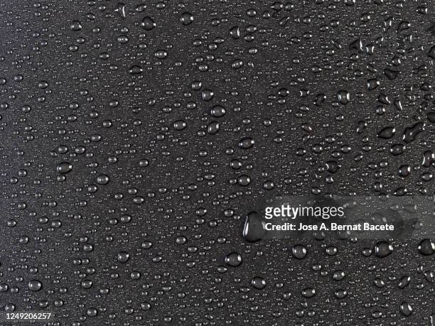 full frame of the textures formed by the bubbles and drops of water on a black background. - gota de lluvia fotografías e imágenes de stock