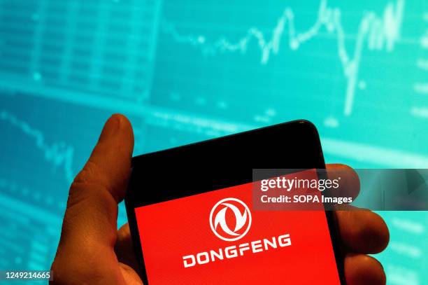 In this photo illustration, the Chinese state-owned automobile manufacturer Dongfeng logo seen displayed on a smartphone with an economic stock...