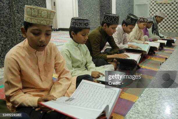 Children read the Koran during the holy fasting month of Ramadan at a madrassa in Mathura on March 24, 2023.