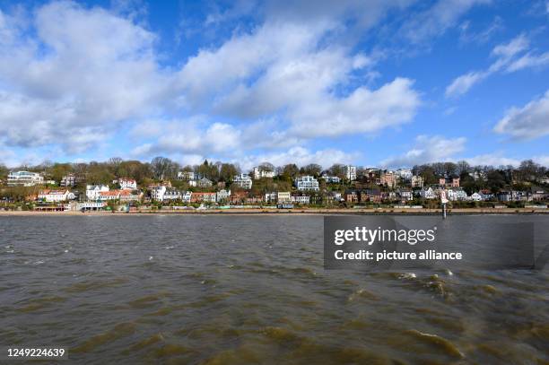 March 2023, Hamburg: Clouds pass in front of a blue sky over the Elbe slope at the Övelgönner Elbstrand. Photo: Jonas Walzberg/dpa