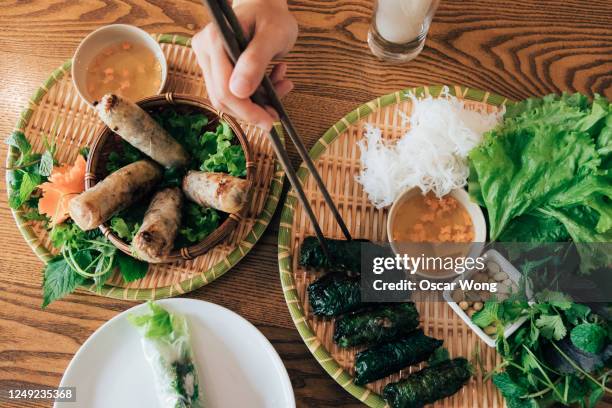 woman eating local traditional vietnamese food with chopsticks - vietnamese food stock pictures, royalty-free photos & images