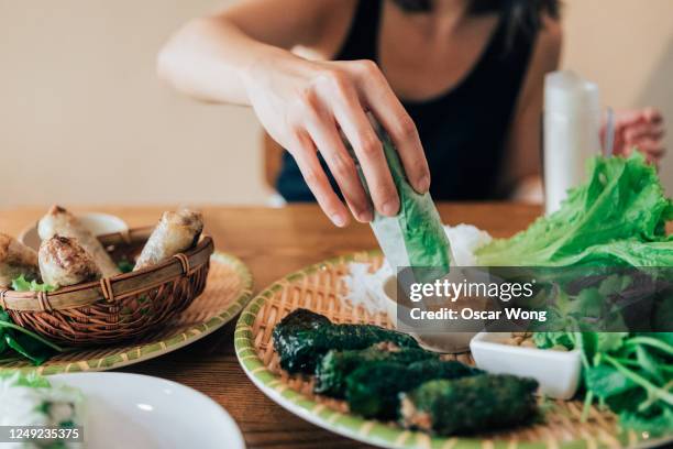 woman eating local traditional vietnamese food - frühlingsrolle stock-fotos und bilder