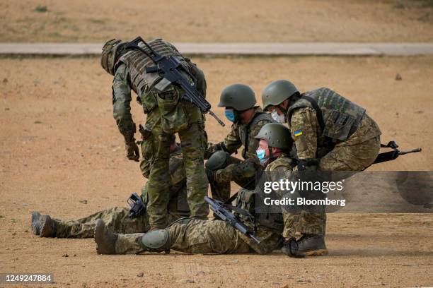 Armed Ukrainian military personnel take part in a medical evacuation training exercise, conducted by the Spanish military, at the Toledo infantry...