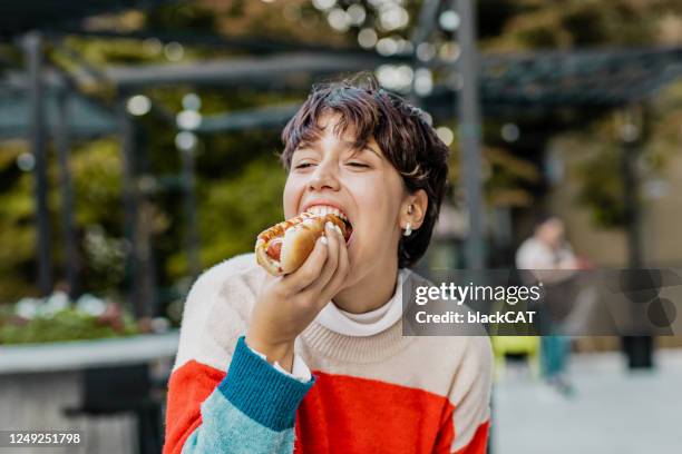 gelukkige vrouw die snel voedsel op de straat eet - eating food happy stockfoto's en -beelden