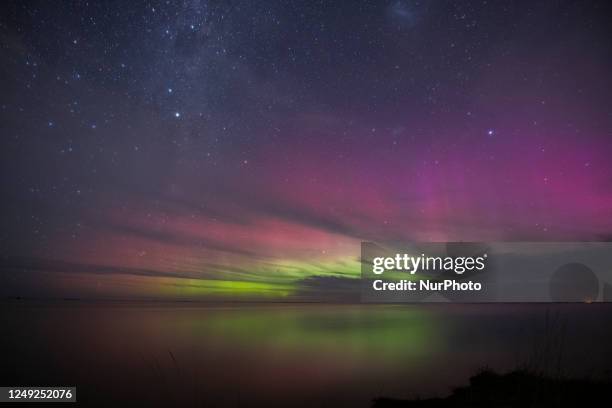 The Aurora, also known as the southern lights, glow on the horizon over the waters of Selwyn Lake in Selwyn Huts, in the Canterbury region, New...