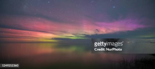 The Aurora, also known as the southern lights, glow on the horizon over the waters of Selwyn Lake in Selwyn Huts, in the Canterbury region, New...