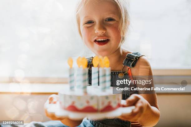 little girl receiving a birthday cake - holding birthday cake stock pictures, royalty-free photos & images