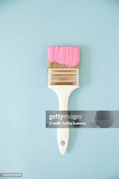 brush in pink paint on light blue surface - pinceau photos et images de collection