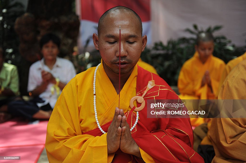 A Buddhist monk leads prayers at the lau