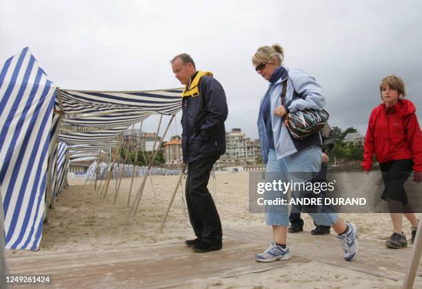 Des touristes marchent sur la plage, le 10 juillet 2007 à Dinard. Même s'ils font grise mine après des mois de mai et juin maussades, les...